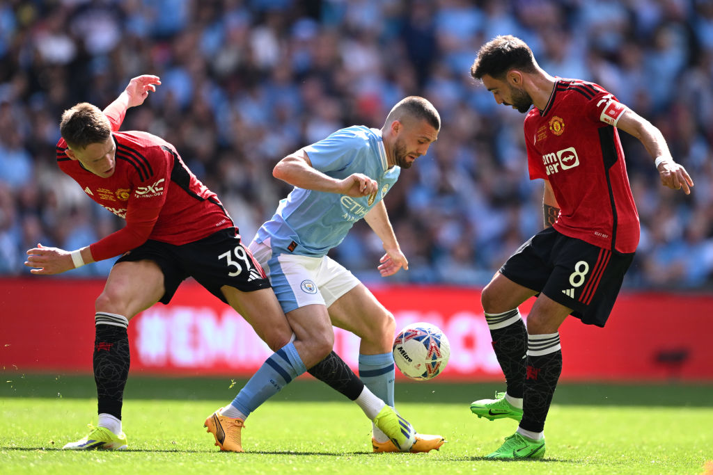 Mateo Kovacic of Manchester City is challenged by Scott McTominay and Bruno Fernandes of Manchester United during the Emirates FA Cup Final live on Showmax Premier League